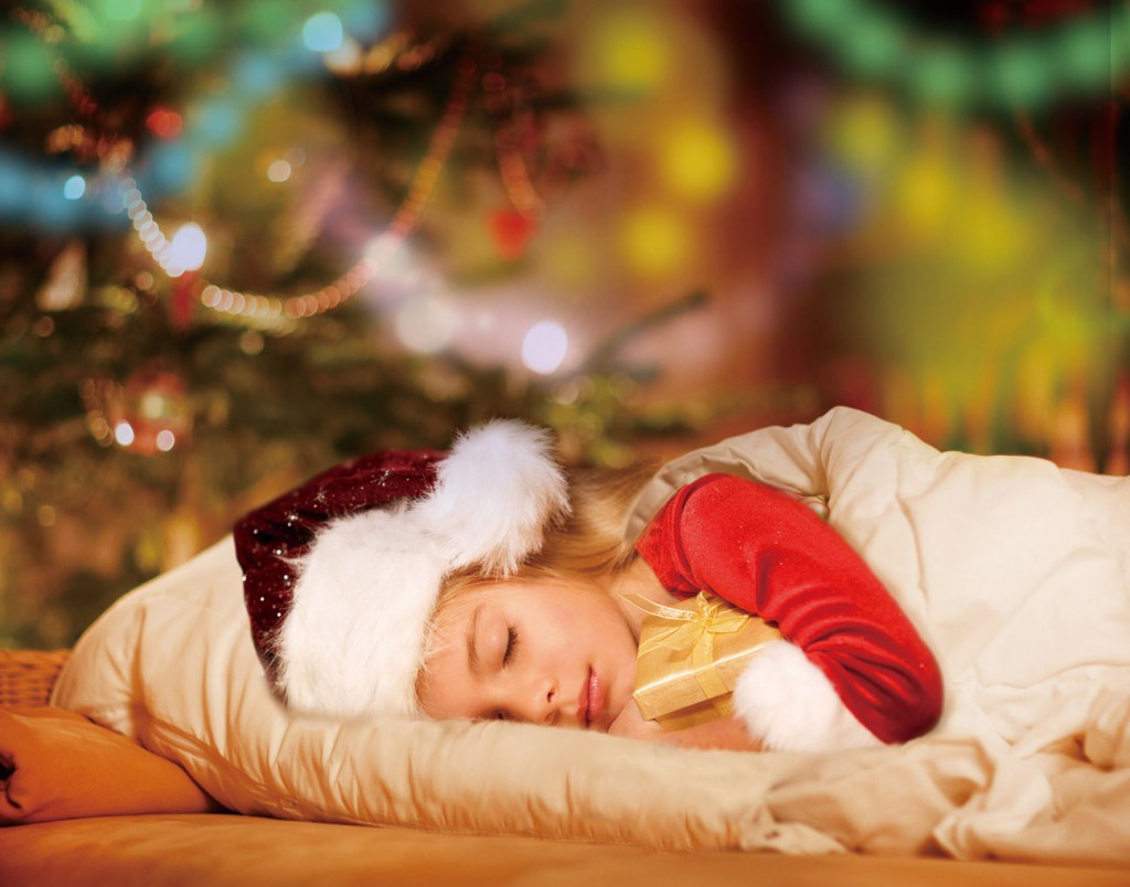 Little cute blond boy sleeping under Christmas tree